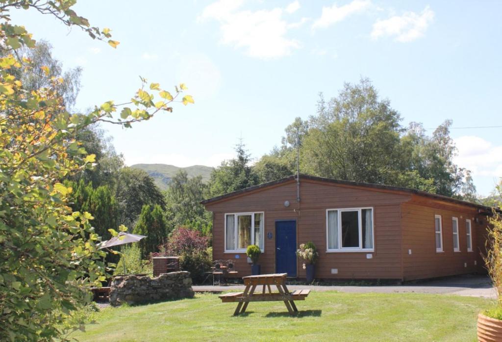 a tiny house with a picnic table in front of it at Woodland Chestnut Lodge in Killin