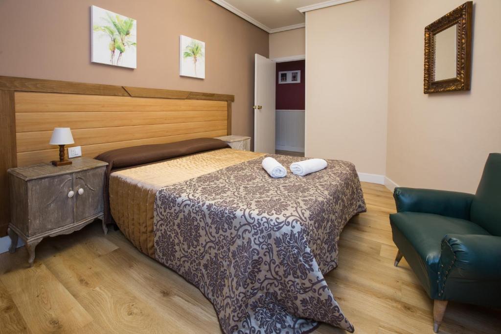 - une chambre avec un lit, un canapé et une chaise dans l'établissement Apartamentos turisticos Avila La Catedral, à Ávila
