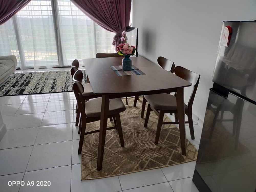 einen Esstisch und Stühle im Wohnzimmer in der Unterkunft Yunne Homestay in Sepang