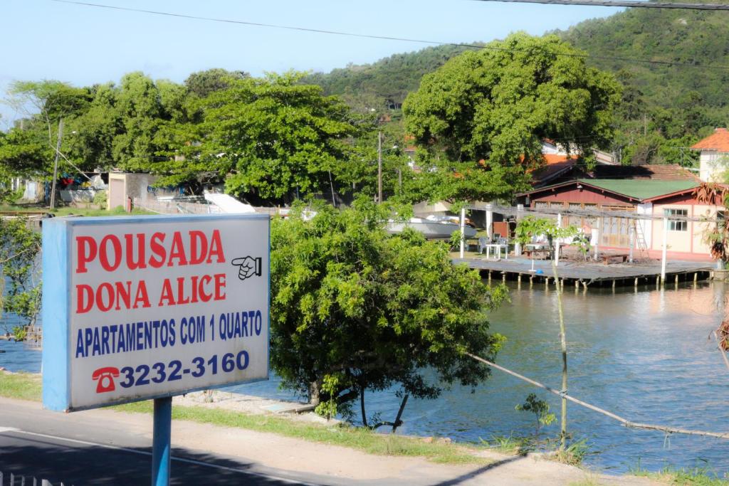 una señal a un lado de una carretera cerca de un cuerpo de agua en Pousada Dona Alice, en Florianópolis