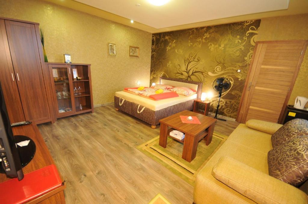 - un salon avec un lit et un canapé dans l'établissement Apartmany Rudolf, à Spišská Nová Ves