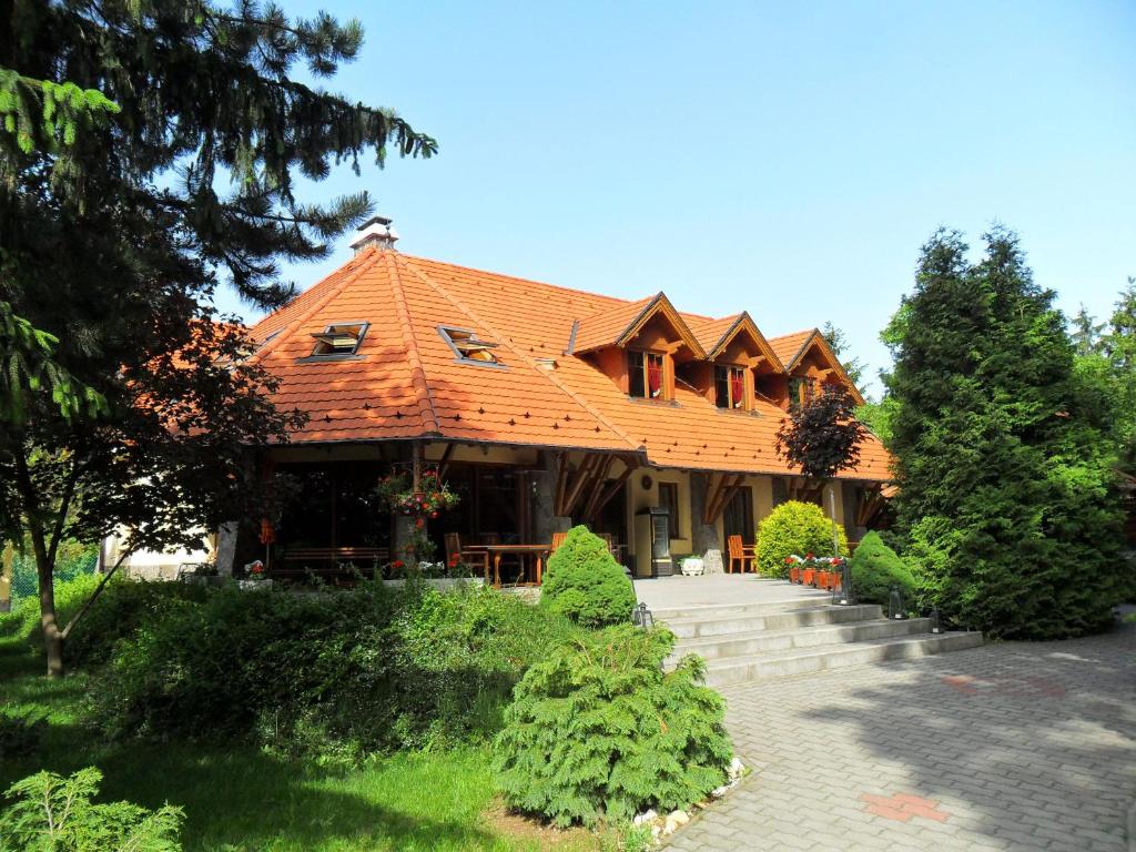 une grande maison avec un toit orange dans l'établissement Napkorong Fogadó és Vendégház, à Piliscsaba