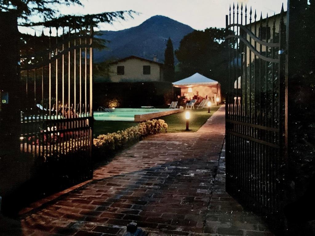 een hek voor een zwembad 's nachts bij Villa Vaccoli in Lucca