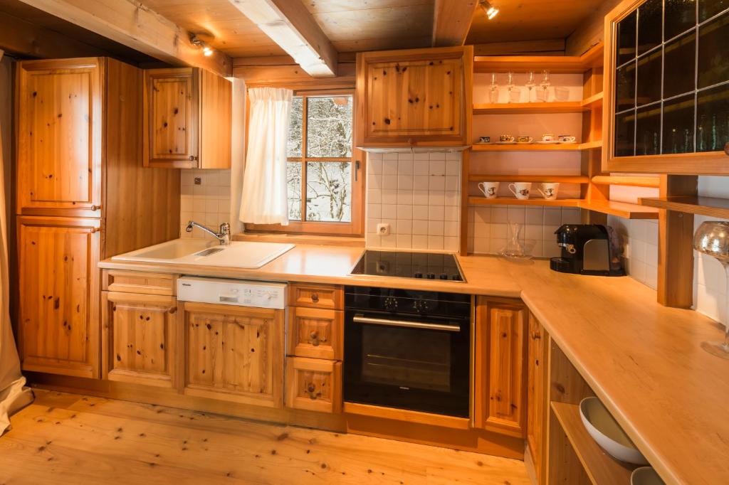 a kitchen with wooden cabinets and a stove top oven at Das Kitz - deLuxe Chalet Valerie in Reith bei Kitzbühel