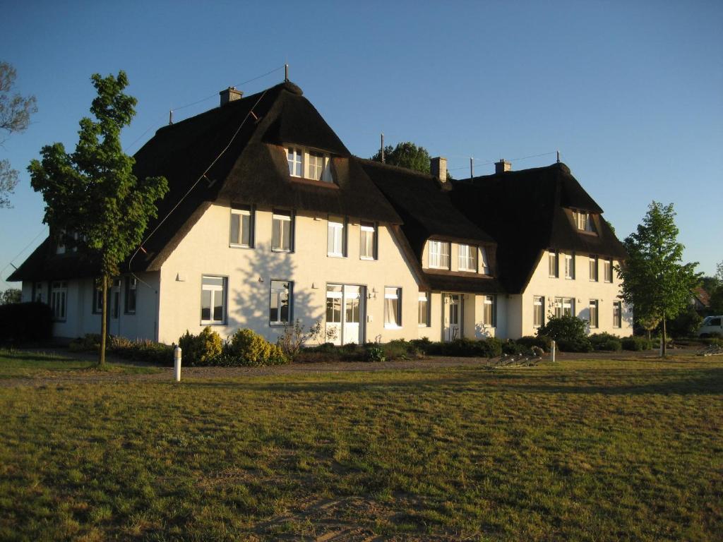 a large white house with a black roof at Landhaus am Haff A9 in Stolpe auf Usedom