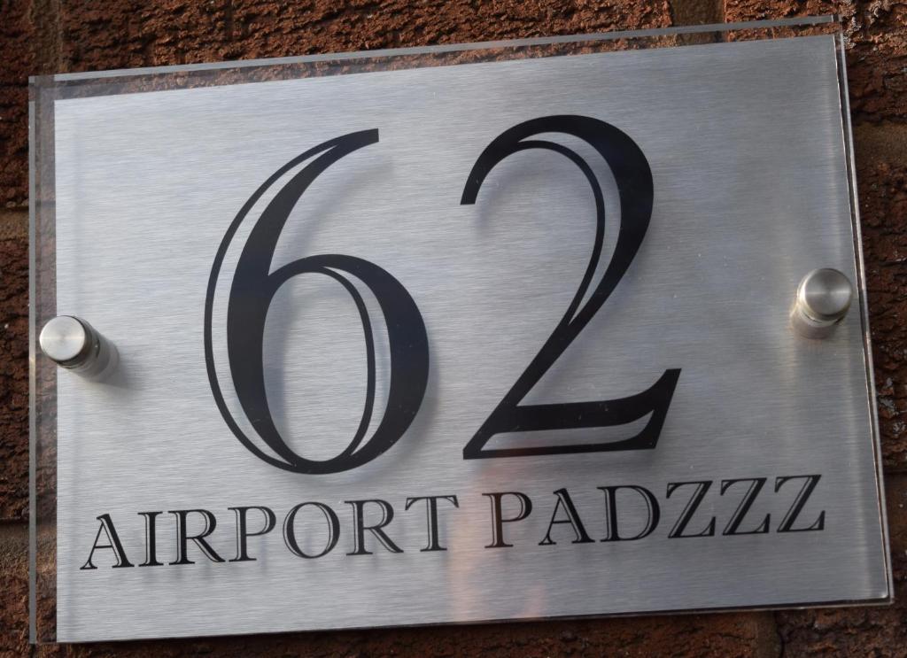 a sign for an airport parking sign on a brick wall at Airport Padzzz in Wythenshawe