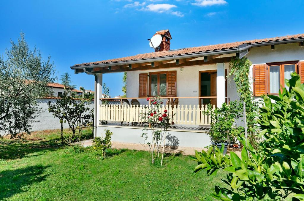 a small white house with a balcony at Adriatico Bungalow in Poreč