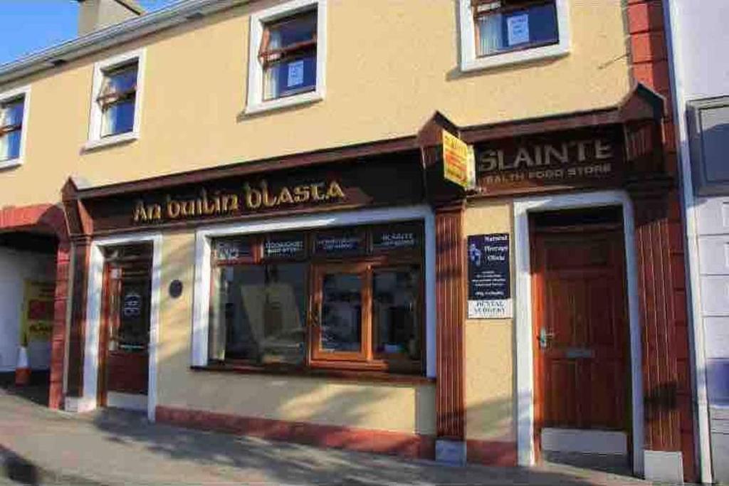 a store on a street with two entrances to a building at Barbers Hall Apartment Town Center in Belmullet