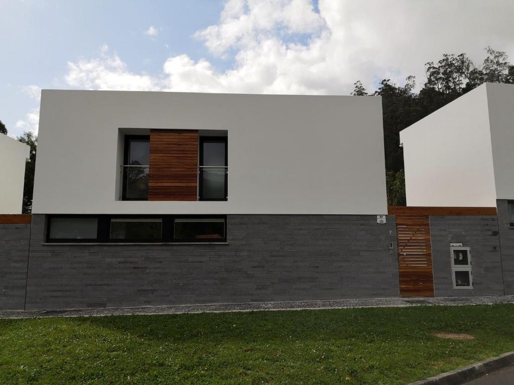a house with a white wall on the side of it at Furnas Springs in Furnas