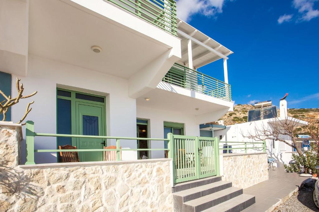 a white house with green doors and stairs at EGLI LUXURY APARTMENTS in Archangelos