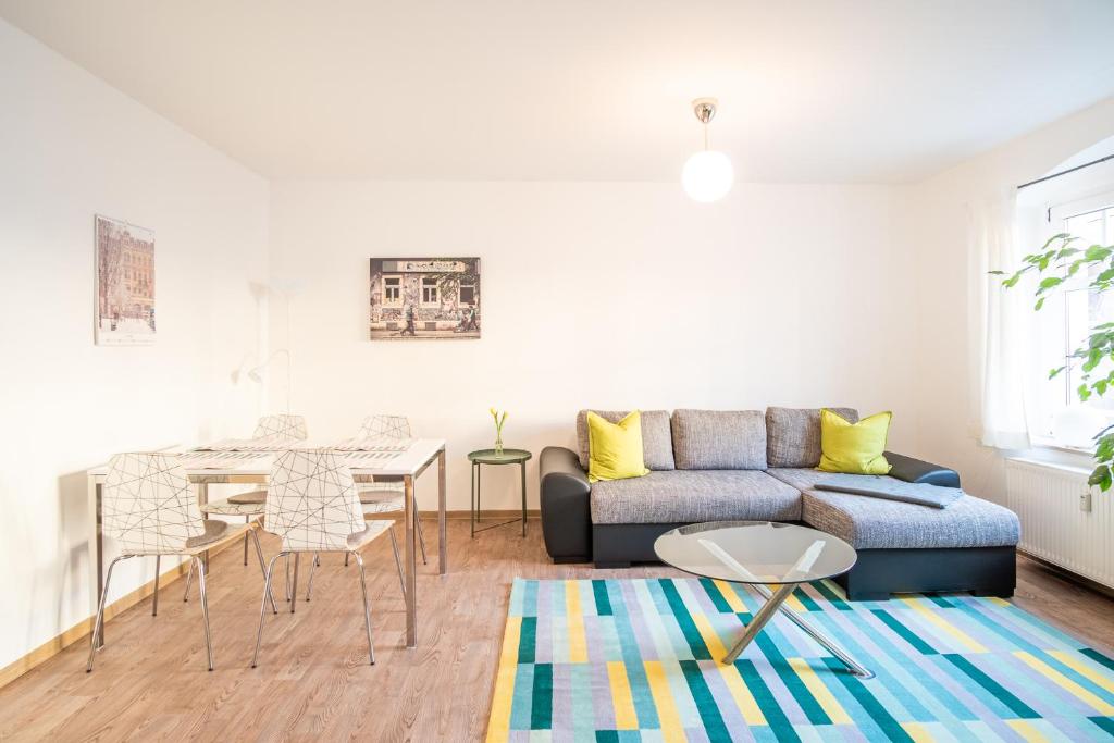 ein Wohnzimmer mit einem Sofa und einem Tisch in der Unterkunft Helle Ferienwohnung im Hinterhof in Dresden