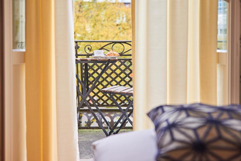 mit Blick auf einen Balkon mit einem Tisch und einem Stuhl in der Unterkunft Saint Georges Hotel in Zürich