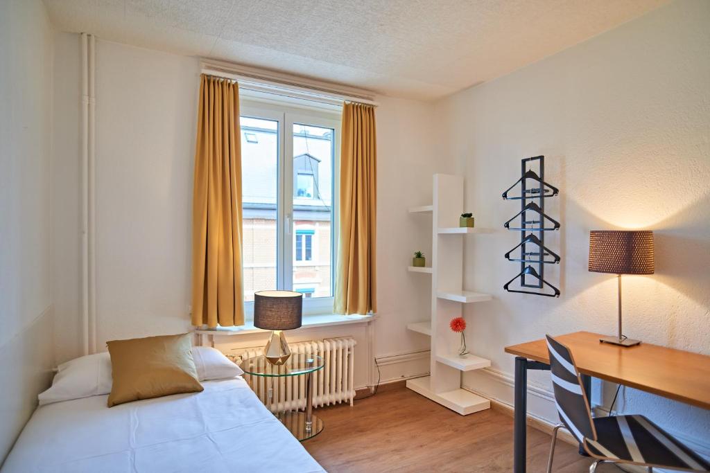um quarto com uma secretária, uma cama, uma secretária e uma janela em Saint Georges Hotel em Zurique