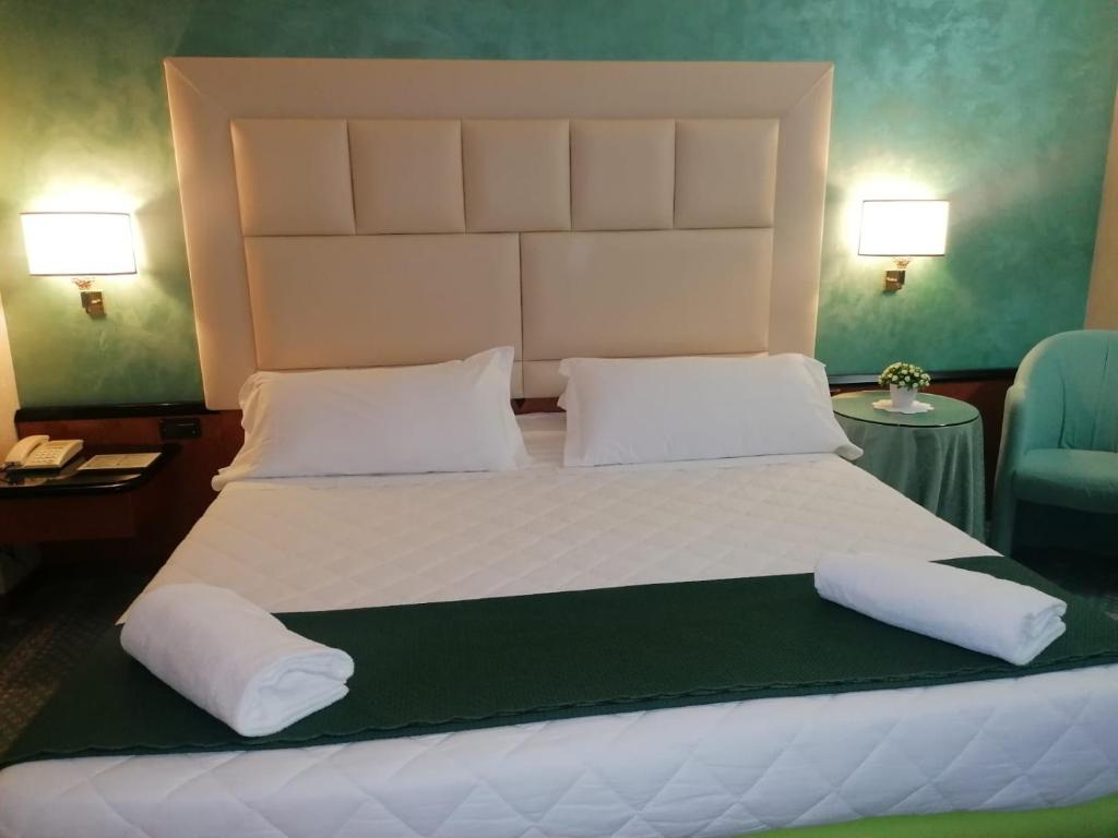 a bedroom with a large white bed with two pillows at Hotel Principe in Pomezia