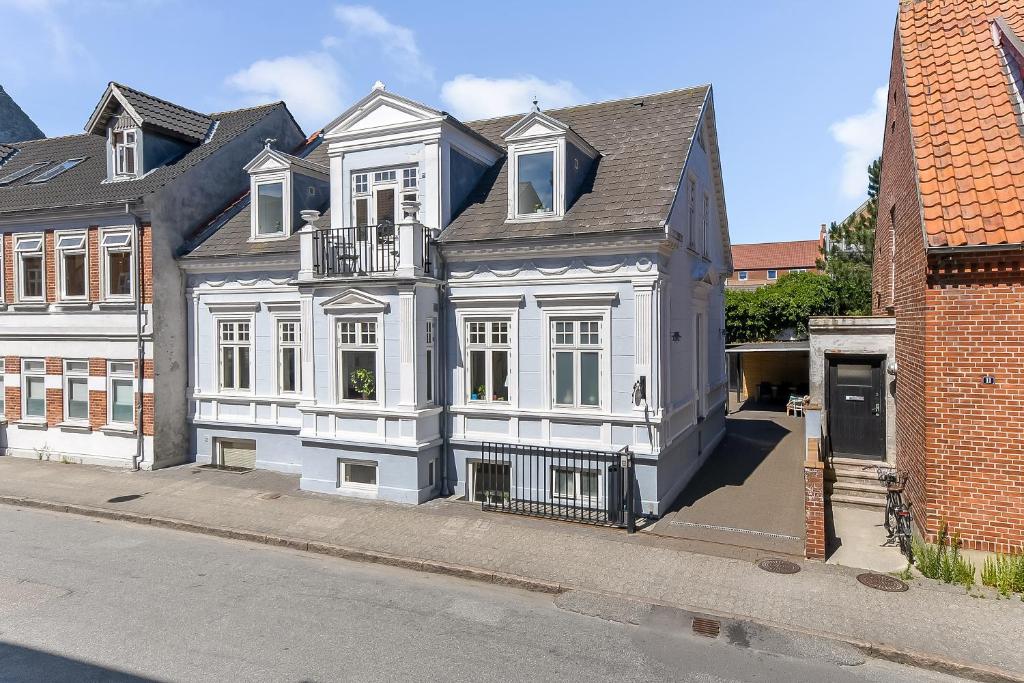 a large white house on the side of a street at Sweethome Guesthouse in Esbjerg