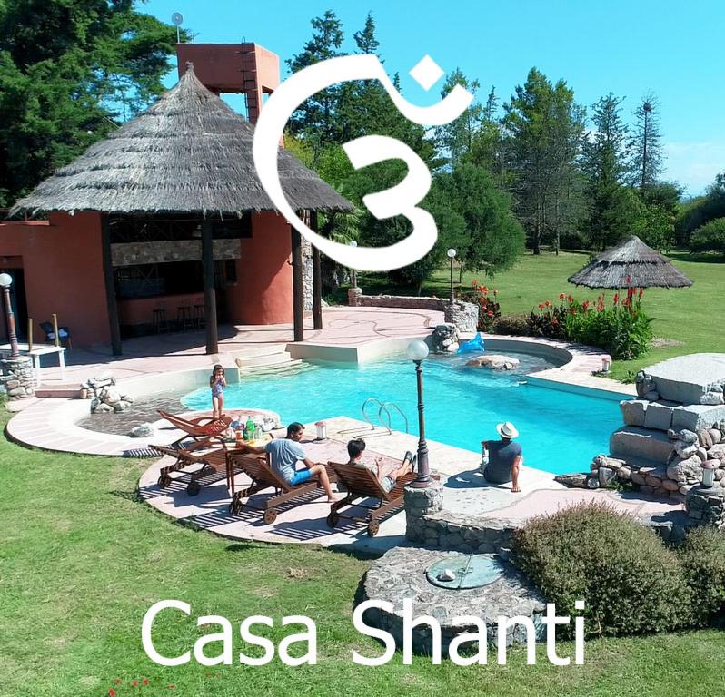 un grupo de personas sentadas alrededor de una piscina en Casa Shanti Posada Boutique en Villa Giardino
