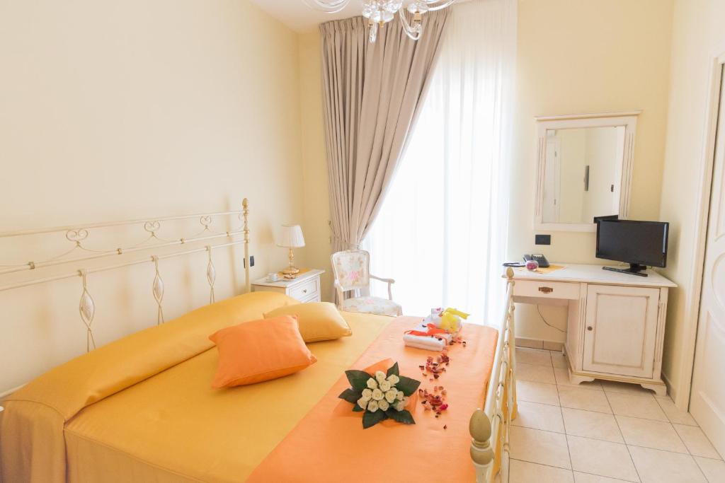 Dormitorio con cama, escritorio y TV en Villa Marchesa en Castelnuovo Cilento