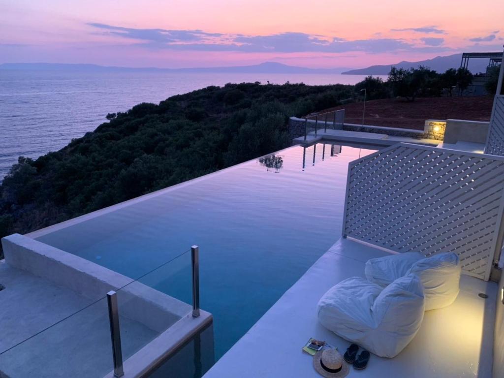 a balcony with a view of the ocean at sunset at Katikies Manis Suites in Kardamili