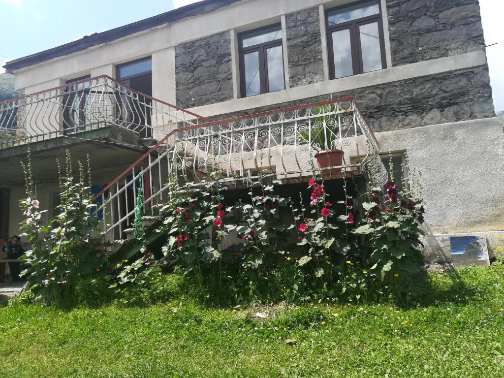 a house with a balcony with flowers on it at Rocky Island in Kazbegi