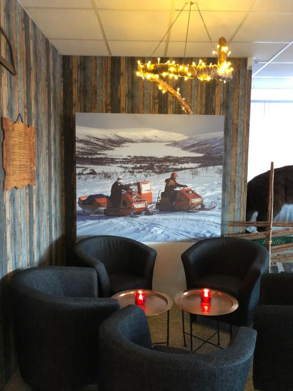 une chambre avec des chaises et des tables devant un tableau dans l'établissement Baren i Ockelbo, à Ockelbo