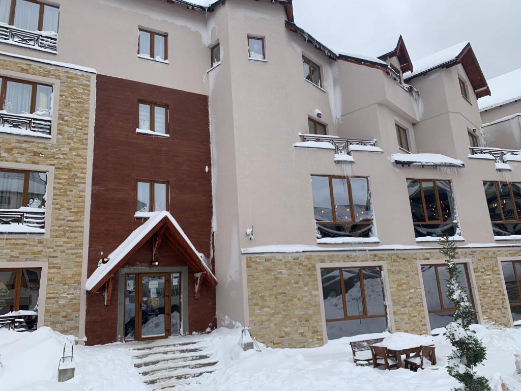 budynek z śniegiem na ziemi przed nim w obiekcie Mount Apartments Milmari w mieście Kopaonik