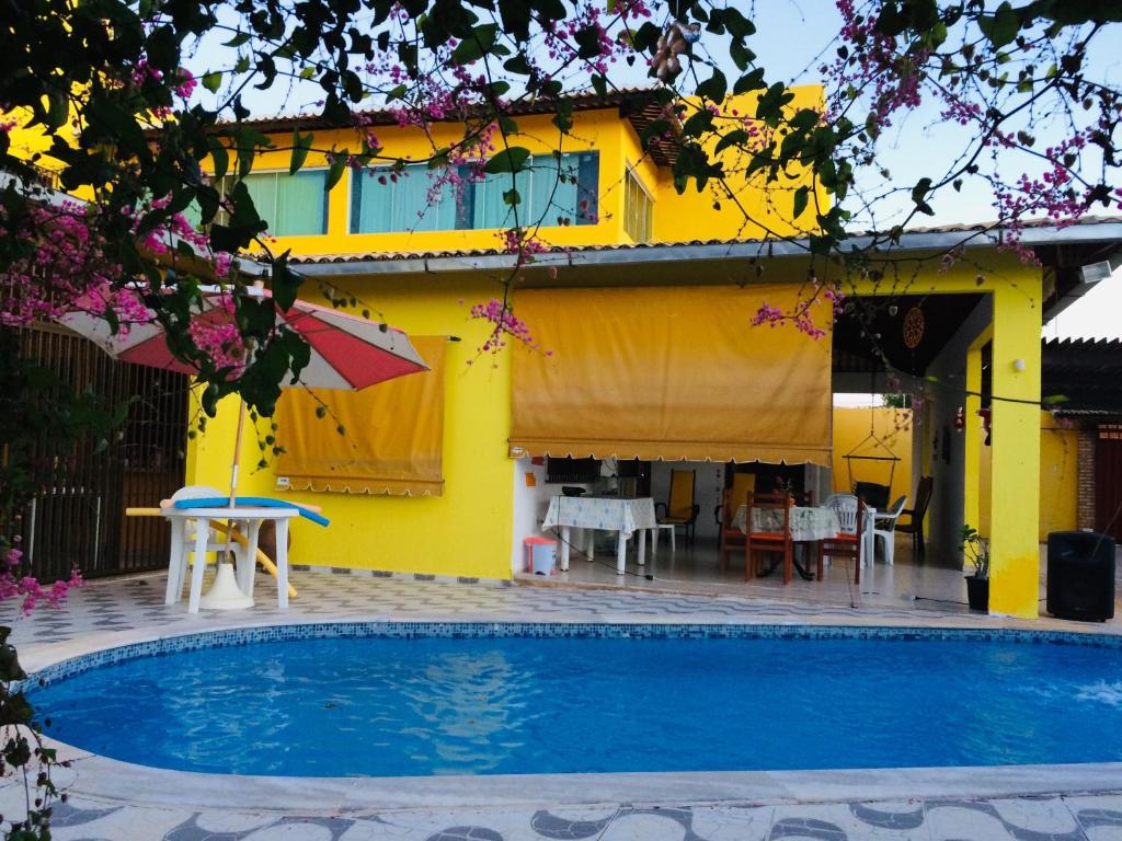a yellow house with a swimming pool in front of it at Ruta Del Sol in Mossoró