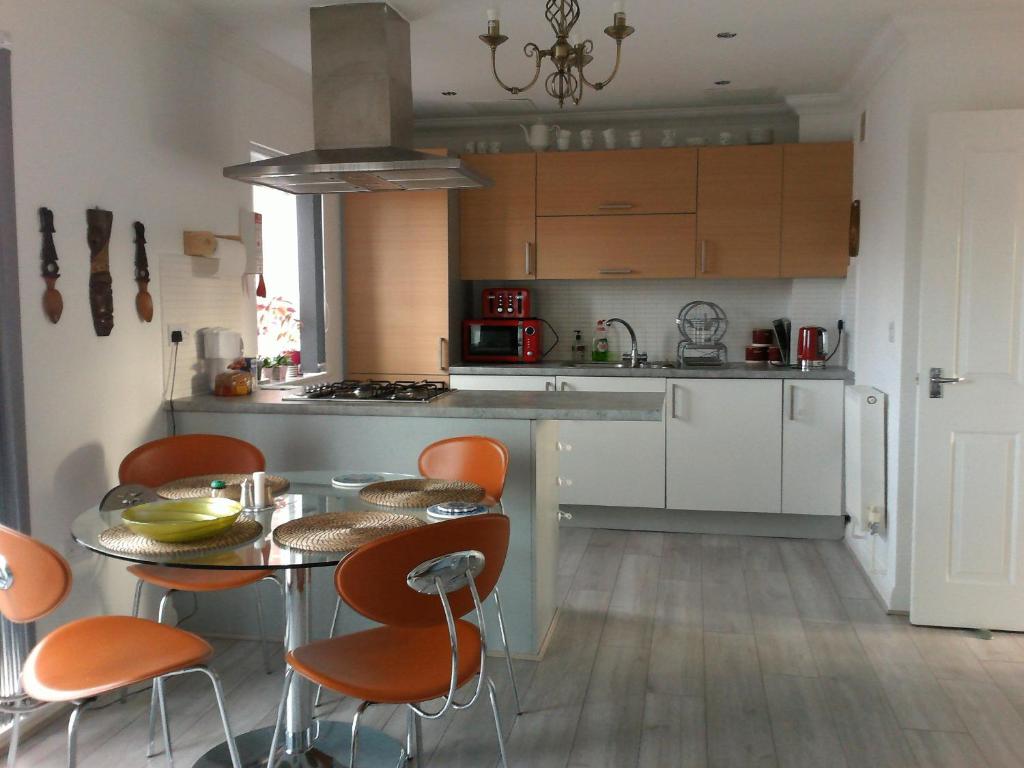 a kitchen with a table and some orange chairs at Two bedroom London Luxury Apartment in London