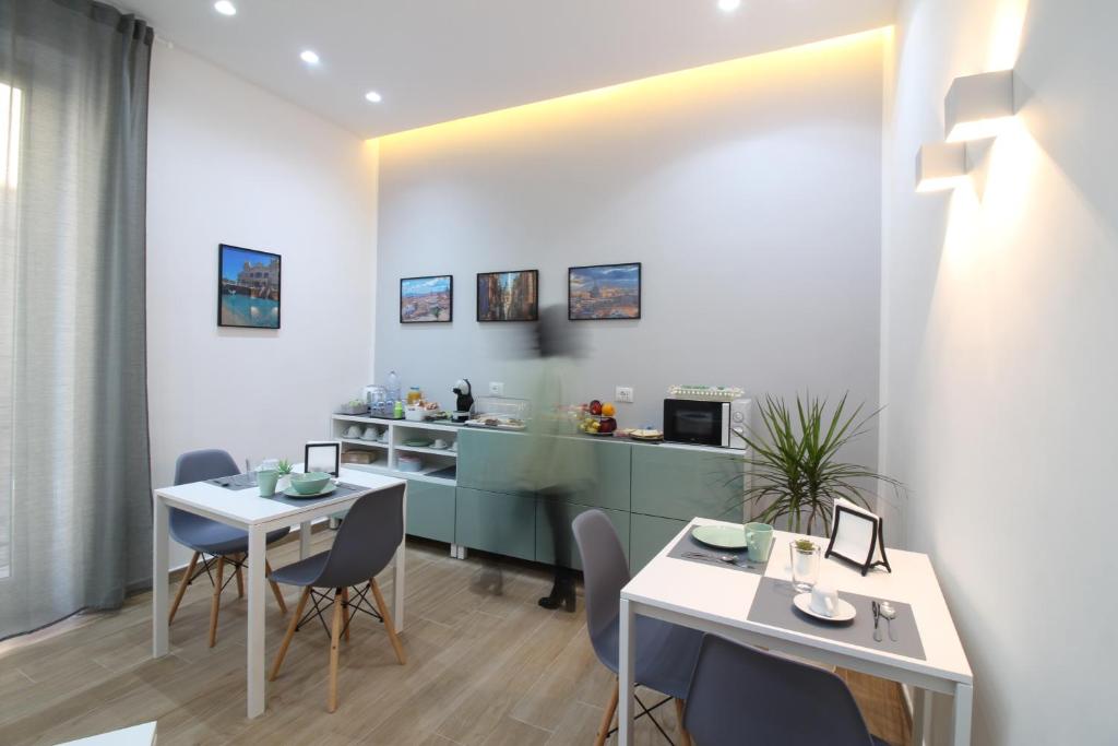 comedor con 2 mesas y cocina en Solli Rooms, en Palermo