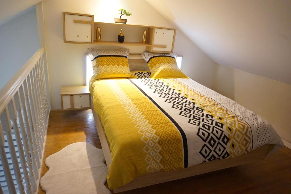 a bedroom with a bed with yellow and white sheets at Appartement de standing in Berck-sur-Mer