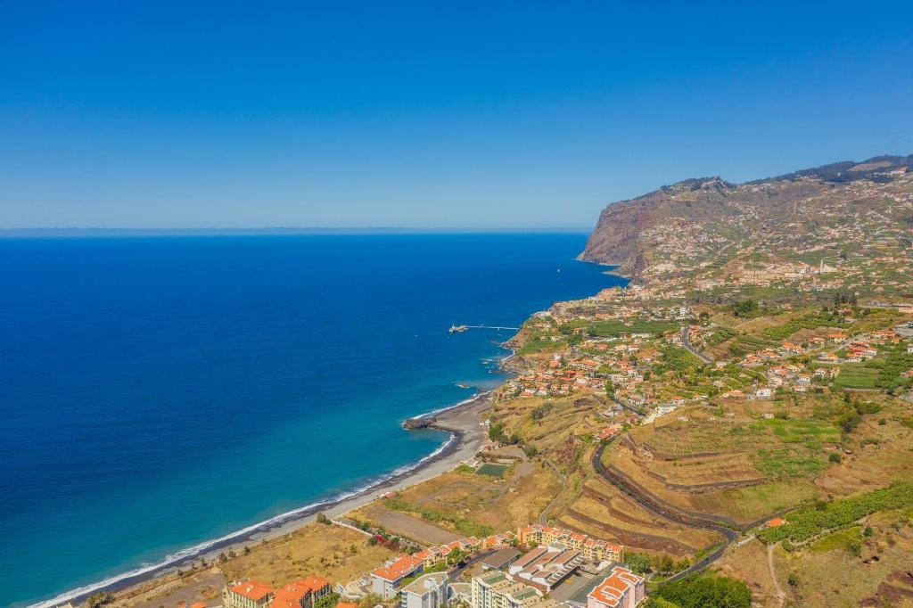 uma vista aérea de uma cidade numa colina junto ao oceano em OCEAN VIEW/DUPLEX/PISCINE/TENNIS Zone VIP Funchal no Funchal