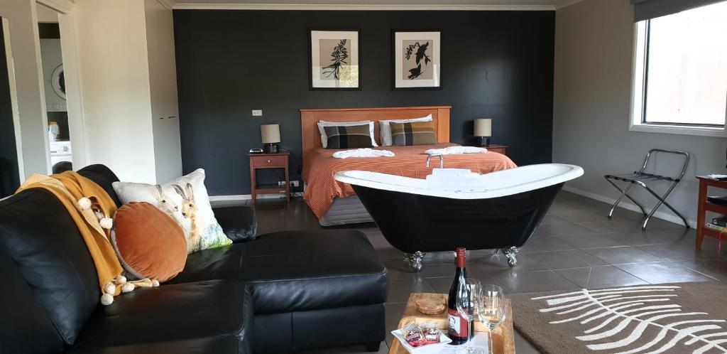 Blaze Rock Retreat في هولز غاب: غرفة معيشة مع سرير وحوض استحمام