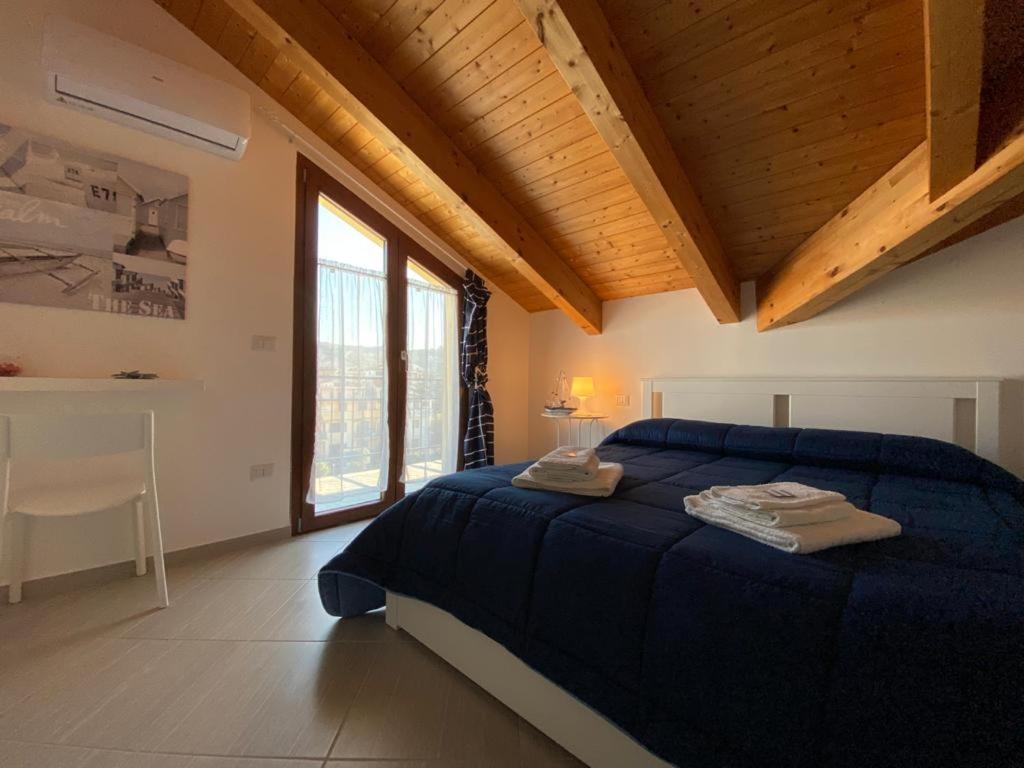 een slaapkamer met een blauw bed met 2 handdoeken erop bij Sapore di mare casa vacanze in Agropoli
