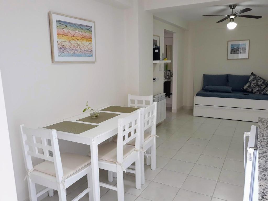 comedor y sala de estar con mesa blanca y sillas en Cómodo y versátil en casco histórico en Salta