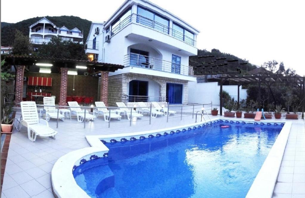 uma casa com piscina em frente a um edifício em Villa Sea-N-Sun, 7 bedrooms & Pool, nearby Portonovi Marina. em Ðenovići