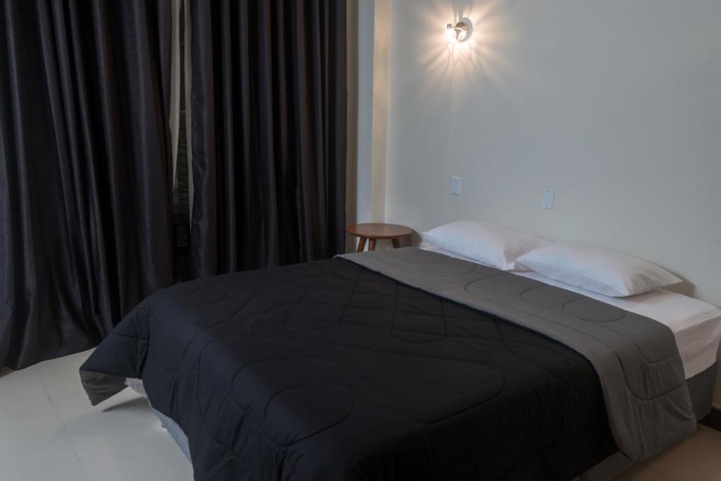 a bedroom with a bed with a black blanket on it at MiniApartamentos GRAN IMPERIAL PREMIUM in Tumbes