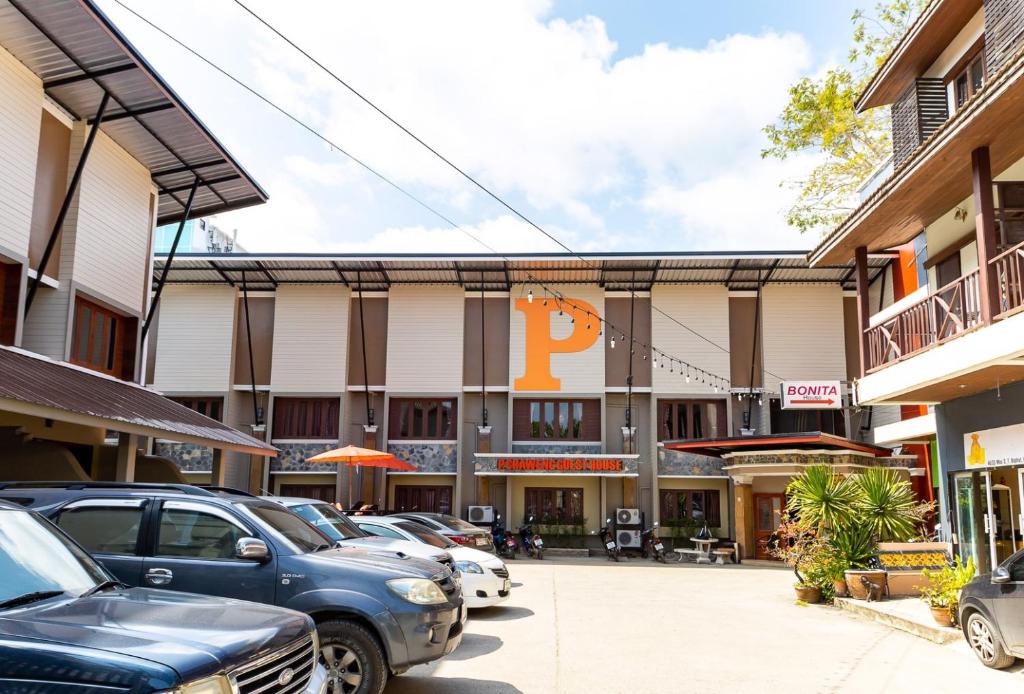 a parking lot with cars parked in front of a building at P Chaweng in Chaweng