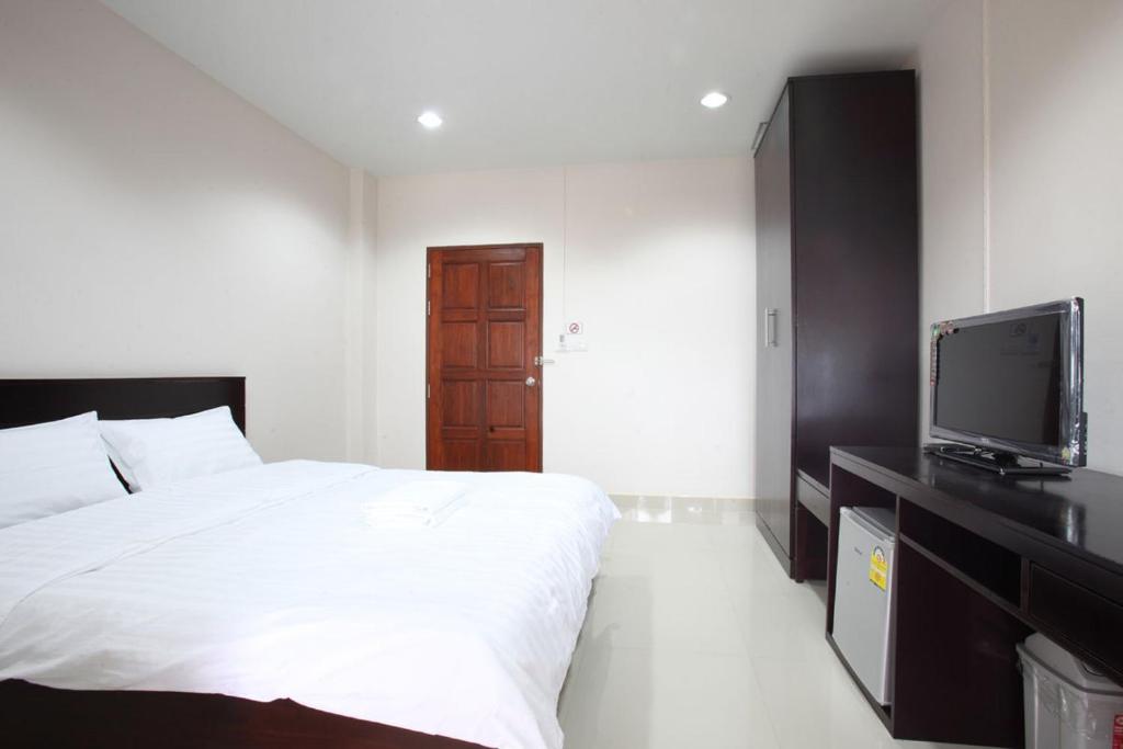um quarto com uma cama e uma televisão de ecrã plano em Garden Hill Hotel em Trang