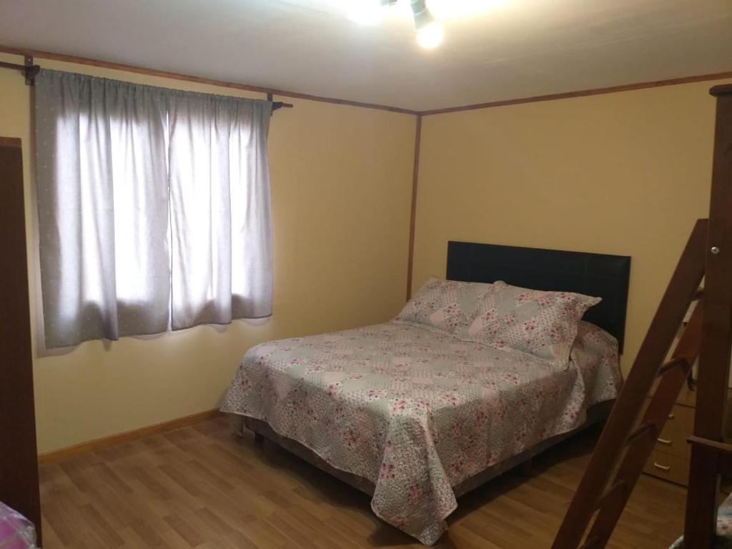 een kleine slaapkamer met een bed en een raam bij Casa Sol y Luna in Ushuaia