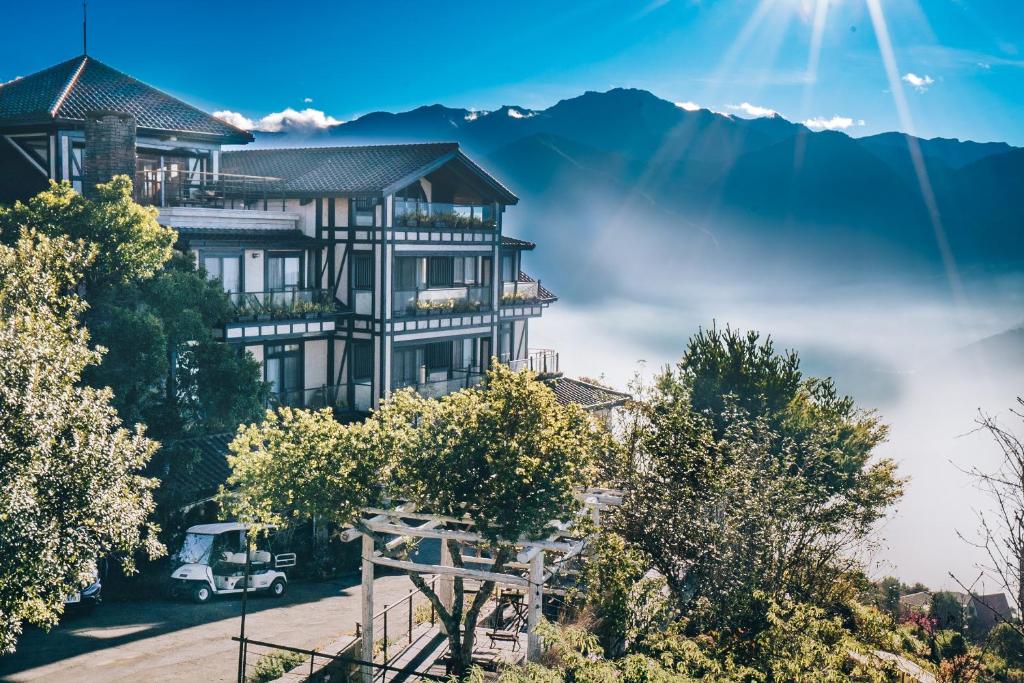 a large house on a hill with mountains in the background at Impression Nordic Manor Club in Ren'ai