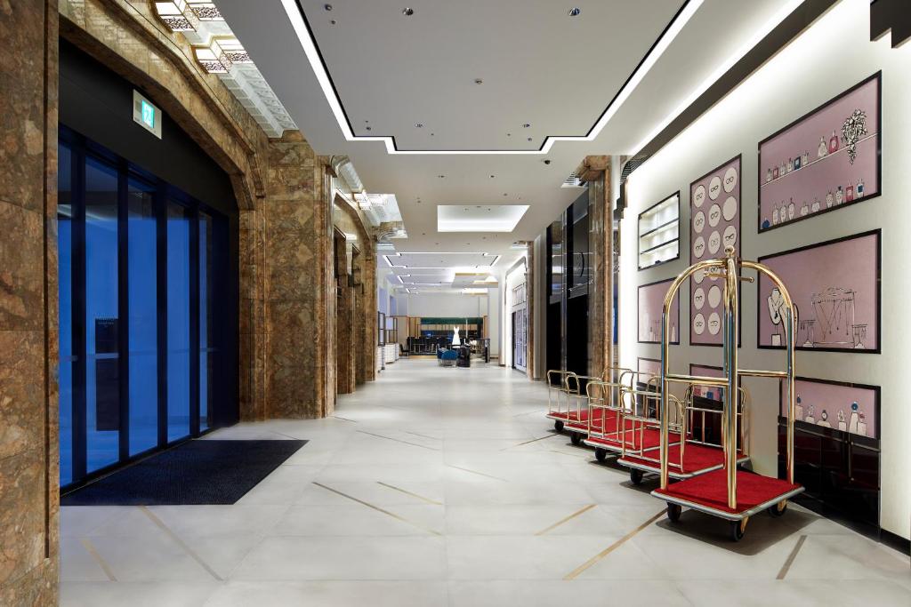 a hallway with red chairs in a building at Citadines Namba Osaka in Osaka