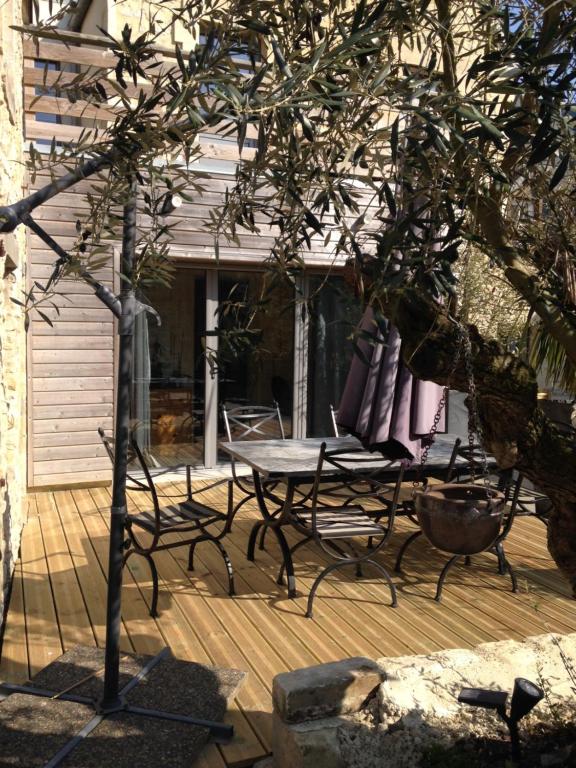 a patio with a table and chairs on a deck at Villa Camélia in Bayeux