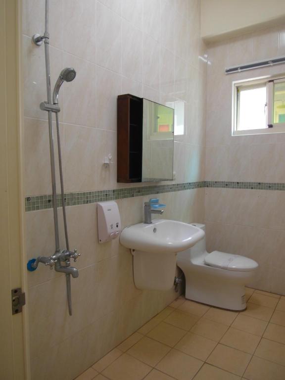 a bathroom with a toilet and a sink and a shower at Sansendai Sea View B&amp;B in Chenggong