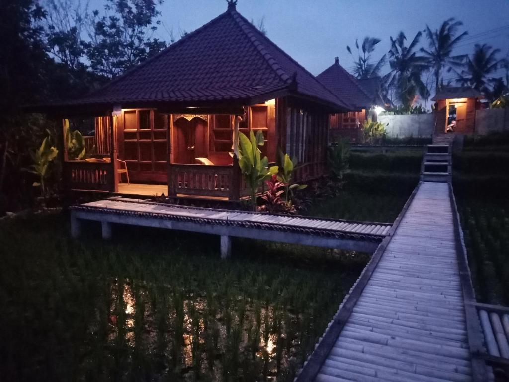 a cabin in the middle of a pond at night at Ubud Sawah Scenery Villa and Homestay in Tegalalang