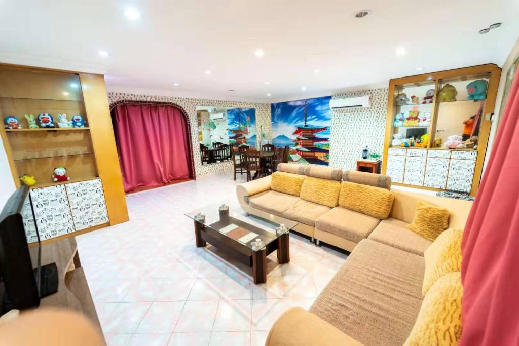 a living room with couches and a tv and a table at Star Light Homestay in Sitiawan