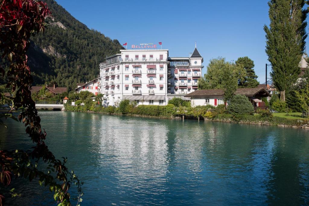 a large white building on the side of a river at Boutique Hotel Bellevue in Interlaken