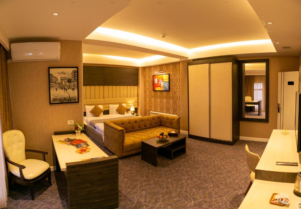 une chambre d'hôtel avec un lit et un canapé dans l'établissement Parkway Inn Hotel & Spa, à Baku