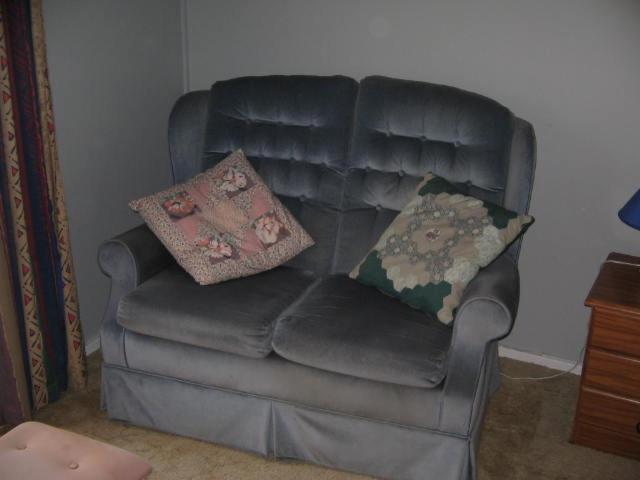 a black leather chair with two pillows on it at The House in Christchurch