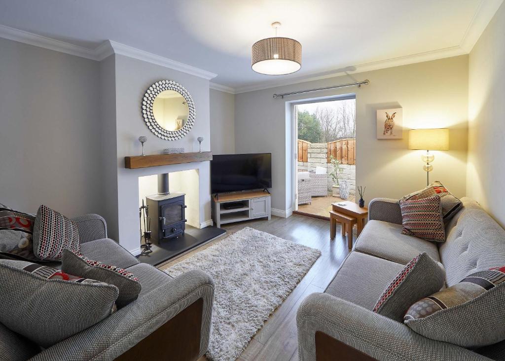 sala de estar con 2 sofás y chimenea en Host & Stay - Lowcross Cottage, en Guisborough