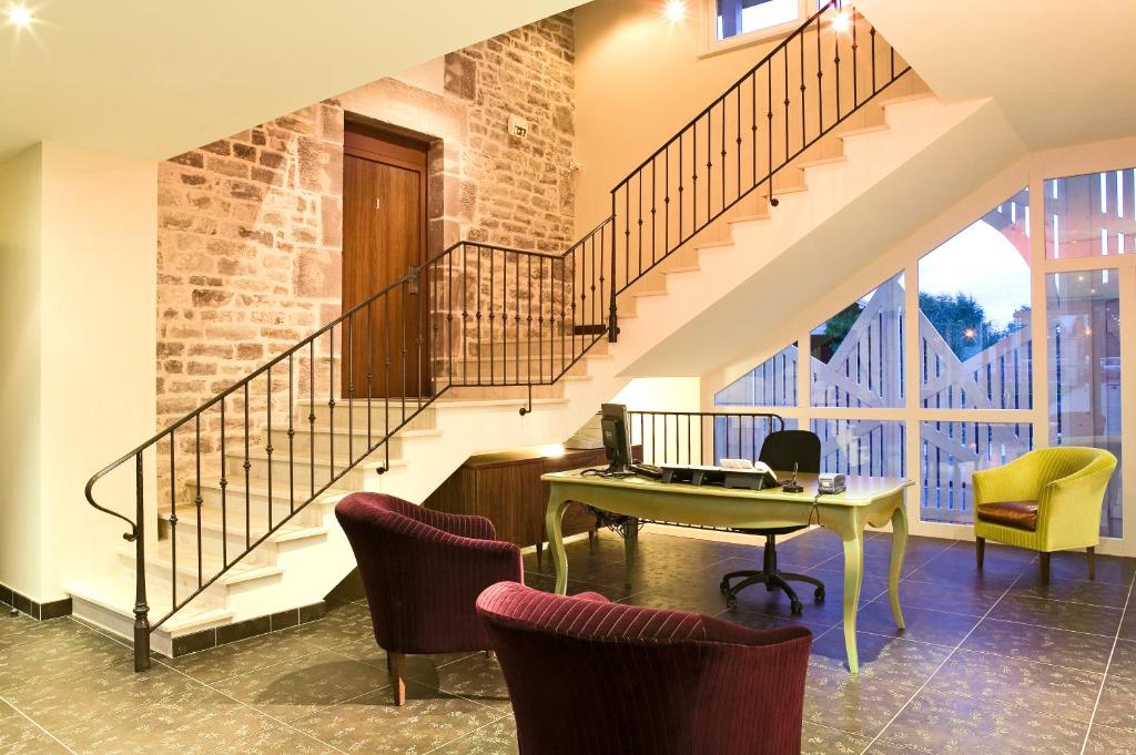 リュクスイユ・レ・バンにあるル クロ レビロットのリビングルーム(階段、テーブル、椅子付)