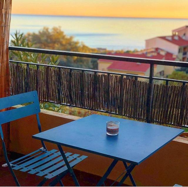 une table bleue et une chaise bleue sur un balcon dans l'établissement Magnifique T1 Bis Vue mer Route des sanguinaires Ajaccio, à Ajaccio